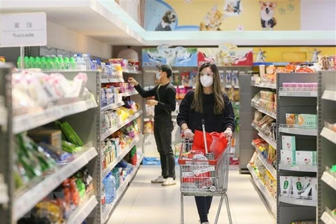 Người dân mua hàng khi các siêu thị được mở cửa trở lại tại thành phố Thượng Hải. (Ảnh: THX/TTXVN) 