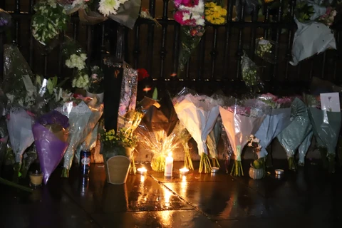 Người dân đặt hoa và nến tưởng niệm dọc theo hàng dào bảo vệ bên ngoài Cung điện Buckingham. (Ảnh: Hải Vân /TTXVN)