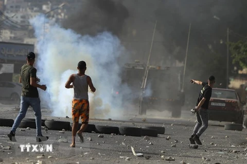 Người biểu tình Palestine ném đá trong cuộc xung đột với binh sỹ Israel tại thành phố Nablus, Khu Bờ Tây ngày 17/8/2022. (Ảnh: AFP/TTXVN)