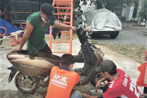 Nhóm Anh em Duy xuyên đến từ tỉnh Quảng Nam sửa xe miễn phí cho sinh viên và người dân khó khăn tại Đà Nẵng. (Ảnh: Văn Dũng/TTXVN)