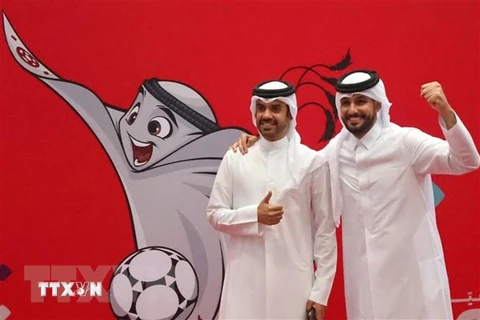 Người dân chụp ảnh bên hình ảnh linh vật World Cup Qatar 2022 ở Doha. (Ảnh: AFP/TTXVN) 