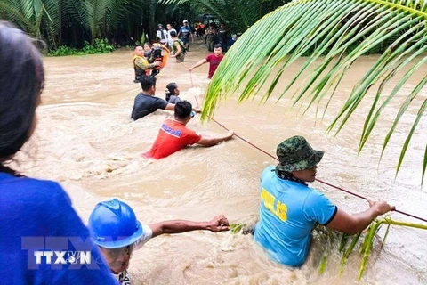 Lực lượng cứu hộ Philippines sơ tán người dân khỏi khu vực ngập lụt do mưa lớn gây ra bởi bão Nalgae ở Kalamansig, Sultan Kudarat, ngày 28/10/2022. (Ảnh: AFP/TTXVN) 