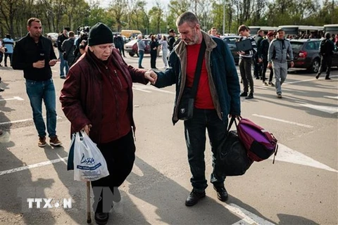 Người dân Ukraine sơ tán từ thành phố Mariupol tới thành phố Zaporizhzhia. (Ảnh: AFP/TTXVN)