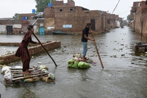Người dân ở thành phố Hyderabad, tỉnh Sindh, đông nam Pakistan, vượt qua nước lũ trên những chiếc bè tự chế hôm 24/8. Ảnh: Reuters. 