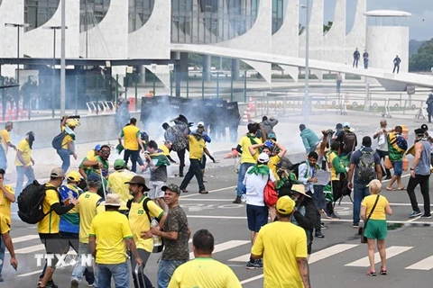 Lực lượng an ninh Brazil nỗ lực ngăn người biểu tình ủng hộ cựu Tổng thống Jair Bolsonaro tràn vào toà nhà Quốc hội ở Brasilia, ngày 8/1/2023. (Ảnh: AFP/TTXVN)