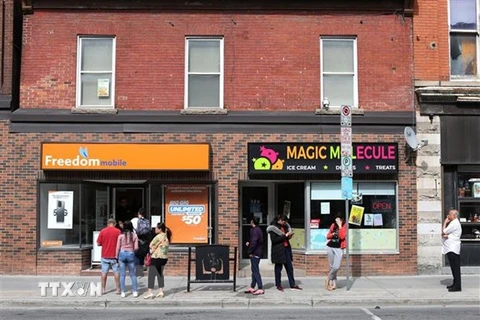 Khách hàng xếp hàng bên ngoài một cửa hàng điện thoại ở Ottawa, Canada. (Ảnh: AFP/TTXVN) 