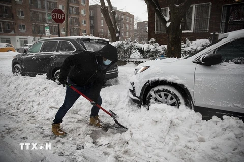 Người dân dọn tuyết trên đường phố. (Nguồn: THX/TTXVN)