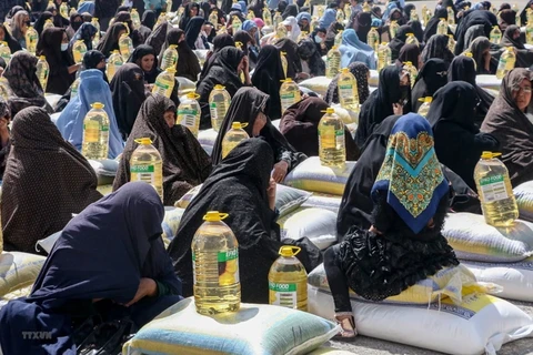 Người dân nhận thực phẩm cứu trợ tại Herat, Afghanistan, ngày 11/4/2023. (Ảnh: AFP/TTXVN) 