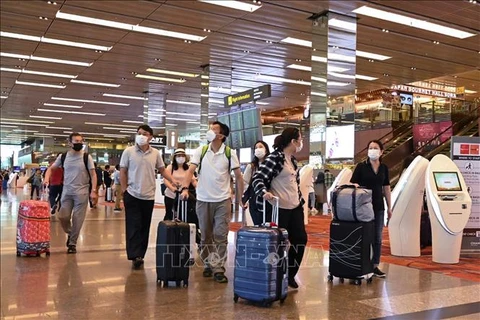 Du khách đeo khẩu trang để phòng tránh lây nhiễm COVID-19 tại sân bay quốc tế Changi, Singapore. (Ảnh: AFP/TTXVN) 