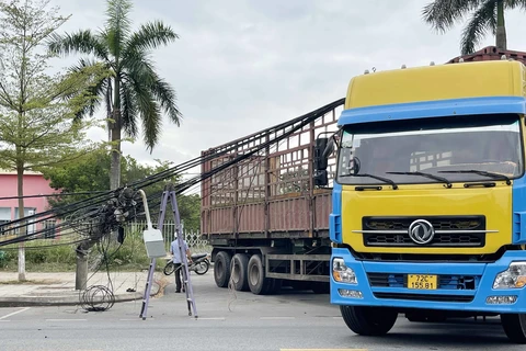 Xe tải vướng vào dây điện đường Nguyễn Văn Linh, phường Trương Quang Trọng làm đổ 4 trụ điện. (Ảnh: Phạm Cường/TTXVN)