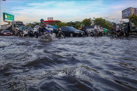 Triều cường gây ngập các tuyến đường ảnh hưởng đến việc đi lại của người dân. (Ảnh: Thanh Liêm/TTXVN)