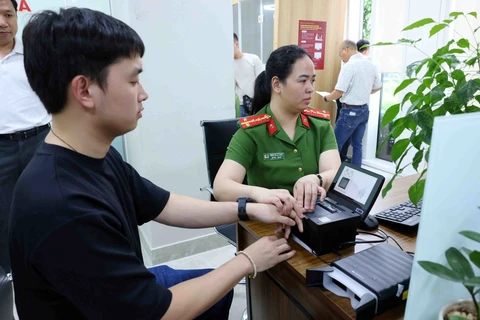 Công dân lấy dấu vân tay khi đến làm thủ tục cấp thẻ căn cước. (Ảnh: Phạm Kiên/TTXVN)