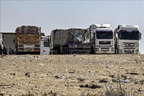 Xe tải chở hàng viện trợ cho Dải Gaza tập trung gần cửa khẩu Rafah bên phía Ai Cập. (Ảnh minh họa: AFP/TTXVN) 