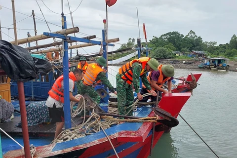 Chính quyền xã Vĩnh Trung (TP Móng Cái) phối hợp với Đồn Biên phòng cửa khẩu cảng Vạn Gia cùng nhân dân cố định, neo đậu tàu, thuyền tránh bão số 2. (Ảnh: TTXVN phát)