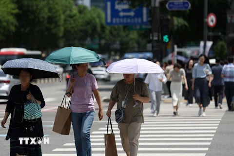 Người dân che ô tránh nắng nóng trên đường phố tại Seoul, Hàn Quốc. (Ảnh: Yonhap/TTXVN)