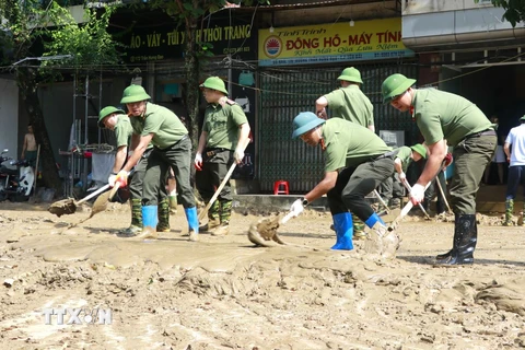 Hàng trăm người gồm bộ đội, công an, dân quân tự vệ, đoàn thanh niên... được huy động hỗ trợ dọn bùn, giúp người dân thành phố Yên Bái sớm ổn định cuộc sống sau đợt lũ. (Ảnh: Tuấn Anh/TTXVN)