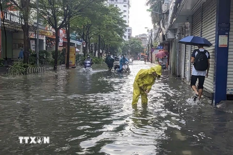 Một số điểm trên phố Triều Khúc bị ngập sâu, giao thông khó khăn. (Ảnh: TTXVN phát)