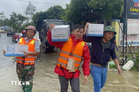 Các lực lượng chức năng và người dân chuẩn bị lương thực hỗ trợ bà con vùng ngập lụt. (Ảnh: Thanh Thuỷ/TTXVN)