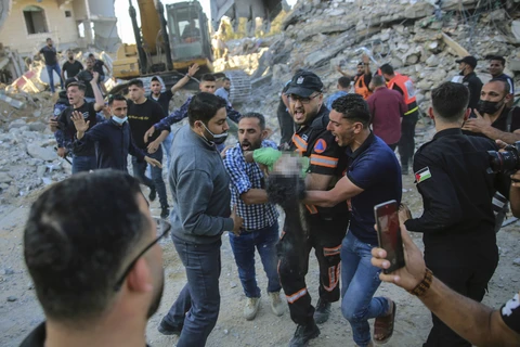 Người Palestine mang thi thể của một đứa trẻ được tìm thấy trong đống đổ nát của một ngôi nhà bị phá hủy trong các cuộc không kích của Israel ở thị trấn Beit Lahiya. (Ảnh: AP)