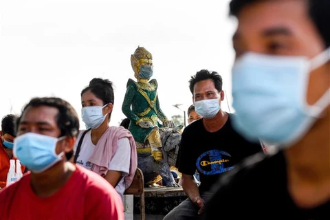 Người dân đeo khẩu trang phòng lây nhiễm tại một điểm tiêm vaccine ngừa COVID-19 ở Phnom Penh, Campuchia, ngày 20/5/2021. (Ảnh: AFP/TTXVN)