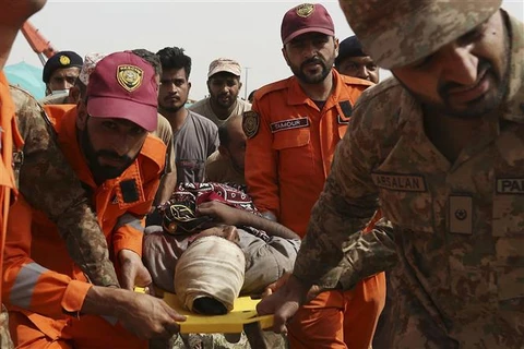 Lực lượng cứu hộ chuyển nạn nhân bị thương tại hiện trường vụ hai đoàn tàu cao tốc đâm vào nhau ở Daharki thuộc tỉnh Sindh, Pakistan ngày 7/6/2021. (Ảnh: AFP/TTXVN)