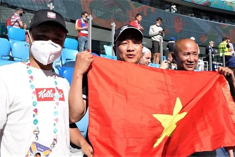 Anh Hoàng Văn Phú (giữa) và anh Nguyễn Đức Vượng (phải) đến từ Vladivostok, cách St. Petersburg 7 múi giờ, để cổ vũ cho đội tuyển Nga. (Ảnh: Duy Trinh/TTXVN)
