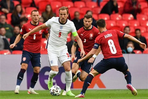 Tiền đạo Anh Harry Kane (áo trắng) trong vòng vây của các cầu thủ Cộng hòa Séc trong trận đấu lượt cuối bảng D EURO 2020, trên sân Wembly tại London. (Ảnh: AFP/TTXVN)