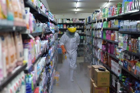 Phun thuốc khử trùng nhằm ngăn chặn sự lây lan của dịch COVID-19 tại một khu chợ ở Bangkok (Thái Lan), ngày 21/6/2021. (Ảnh: THX/ TTXVN)
