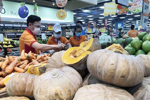 Nhân viên siêu thị tại Thành phố Hồ Chí Minh bổ sung hàng hóa đầy các quầy phục vụ người tiêu dùng. (Ảnh: Mỹ Phương/TTXVN)