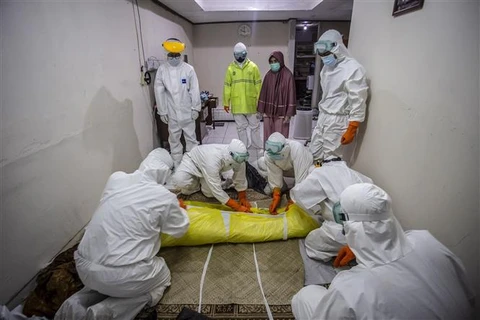 Nhân viên y tế chuyển thi thể bệnh nhân tử vong do COVID-19 tại Bogor, Tây Java (Indonesia), ngày 6/7/2021. (Ảnh: AFP/TTXVN)