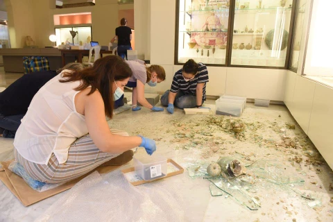 Nhân viên của Bảo tàng Khảo cổ học Beirut tại Đại học American thu nhặt mảnh vụn của các bình thủy tinh bị vỡ trong vụ nổ tại cảng Beirut, hồi tháng 8/2020. (Nguồn: theartnewspaper.com)