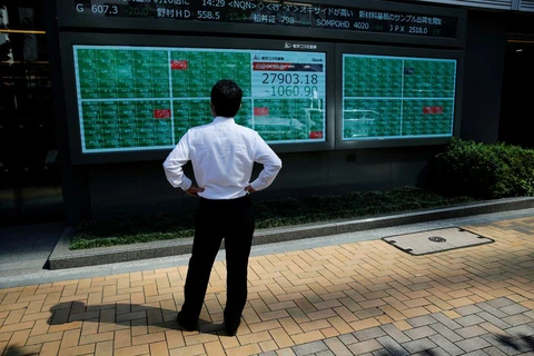 Một người theo dõi bảng điện tử hiển thị chỉ số Nikkei bên ngoài một công ty chứng khoán ở Tokyo (Nhật Bản), ngày 21/6/2021. (Nguồn: reuters.com)