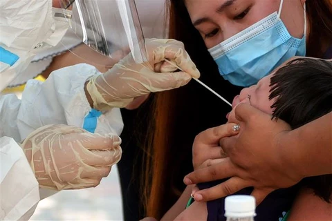Nhân viên y tế lấy mẫu xét nghiệm COVID-19 cho người dân tại thành phố Trịnh Châu, tỉnh Hà Nam (Trung Quốc), ngày 31/7/2021. (Ảnh: AFP/TTXVN)