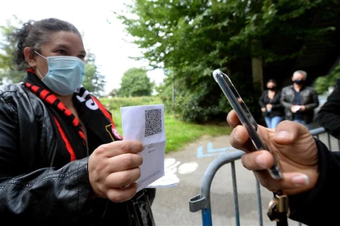 Xuất trình thẻ thông hành y tế trước khi vào xem một trận bóng đá tại sân vận động ở Rennes (Pháp), ngày 8/8/2021. (Ảnh: AFP/TTXVN)