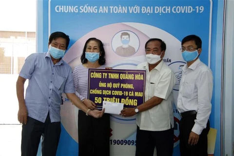 Đại diện Công ty TNHH Quảng Hòa trao số tiền 50 triệu đồng ủng hộ Quỹ phòng, chống dịch COVID-19 của tỉnh Cà Mau. (Ảnh: Kim Há/TTXVN)