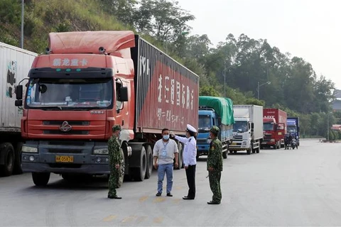 Lực lượng chức năng kiểm tra thân nhiệt lái xe khi ra, vào khu vực cửa khẩu Tân Thanh (tỉnh Lạng Sơn). (Ảnh: Thái Thuần/TTXVN)