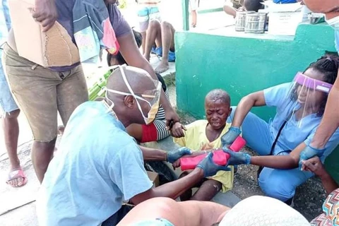 Các bác sỹ Cuba chữa trị cho một em bé bị thương trong trận động đất ở Les Cayes (Haiti), ngày 14/8/2021. (Ảnh: THX/TTXVN)