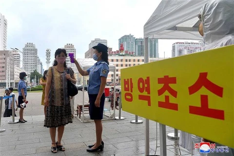 Đo thân nhiệt nhằm ngăn chặn sự lây lan của dịch COVID-19 tại Bình Nhưỡng (Triều Tiên). (Ảnh: AFP/TTXVN)