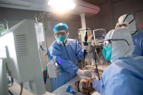 Nhân viên y tế điều trị cho bệnh nhân COVID-19 tại một bệnh viện ở Hồ Bắc (Trung Quốc). (Ảnh: AFP/TTXVN)