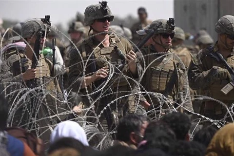 Binh sỹ Mỹ đảm bảo an ninh khi dòng người Afghanistan sơ tán lánh nạn đổ về tuyến đường gần khu quân sự của sân bay quốc tế Kabul, ngày 20/8/2021. (Ảnh: AFP/TTXVN)