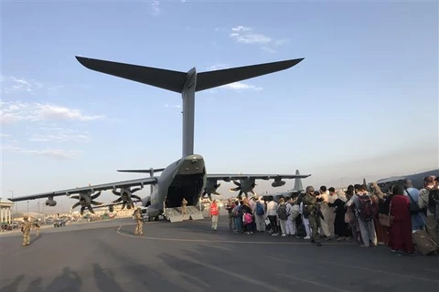 Người dân xếp hàng chờ lên máy bay quân sự Đức để rời Afghanistan tại sân bay Kabul, ngày 24/8/2021. (Ảnh: THX/TTXVN)