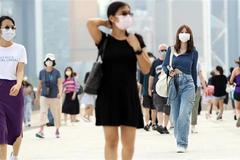 Người dân đeo khẩu trang và thực hiện giãn cách tại Hong Kong (Trung Quốc) khi dịch COVID-19 bùng phát, ngày 2/4/2021. (Ảnh: THX/TTXVN)