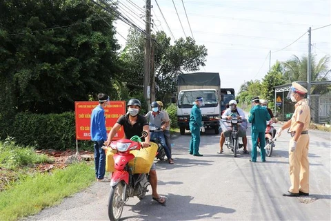 Siết chặt kiểm soát người và phương tiện thu mua nông sản nhằm hạn chế tối đa lây nhiễm COVID-19 trong cộng đồng, tại tỉnh Tiền Giang. (Ảnh: Hữu Chí/TTXVN)