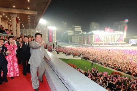 Nhà lãnh đạo Triều Tiên Kim Jong-un vẫy chào các binh sỹ, khán giả và những người tham gia cuộc diễu hành. (Nguồn: aljazeera.com)