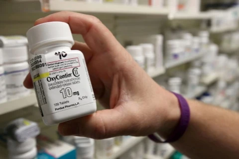Một dược sỹ cầm chai OxyContin do Purdue Pharma sản xuất tại một hiệu thuốc ở Provo, Utah (Mỹ), ngày 9/5/2019. (Nguồn: reuters.com)