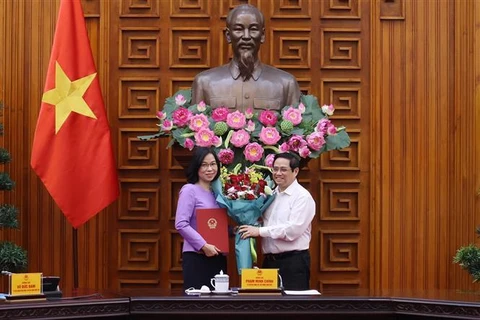 Thủ tướng Phạm Minh Chính trao Quyết định bổ nhiệm Tổng Giám đốc Thông tấn xã Việt Nam cho bà Vũ Việt Trang. (Ảnh: Dương Giang/TTXVN)