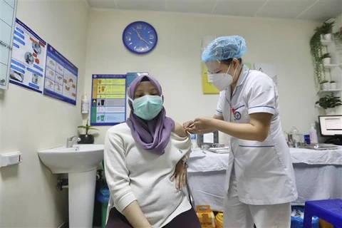 Nhân viên y tế tiêm vaccine cho phụ nữ mang thai là nhân viên Đại sứ quán Malaysia tại Việt Nam. (Ảnh: Minh Quyết/TTXVN)