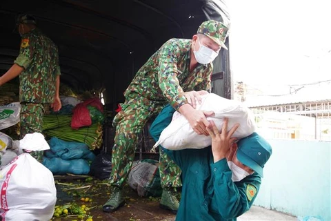 Bộ đội Biên phòng Tiền Giang tham gia vận chuyển gạo, rau củ quả cùng các hàng nhu yếu phẩm cho một khu vực phong tỏa. (Ảnh: Hữu Chí/TTXVN)