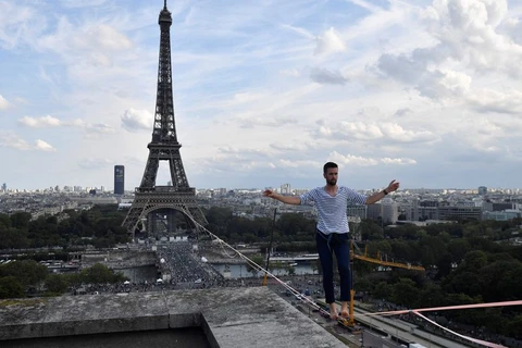 Vận động viên người Pháp Nathan Paulin biểu diễn đi trên dây ở độ cao 70m, với khoảng cách 670m giữa Tháp Eiffel và Nhà hát National de Chaillot, trong khuôn khổ Ngày Di sản Châu Âu và sự kiện ra mắt Olympic Văn hóa tại Paris, ngày 18/9/2021. (Nguồn: nyd