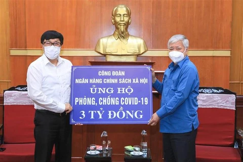 Chủ tịch Ủy ban Trung ương Mặt trận Tổ quốc Việt Nam Đỗ Văn Chiến (phải) tiếp nhận số tiền ủng hộ từ Công đoàn Ngân hàng Chính sách xã hội. (Ảnh: Minh Đức/TTXVN)
